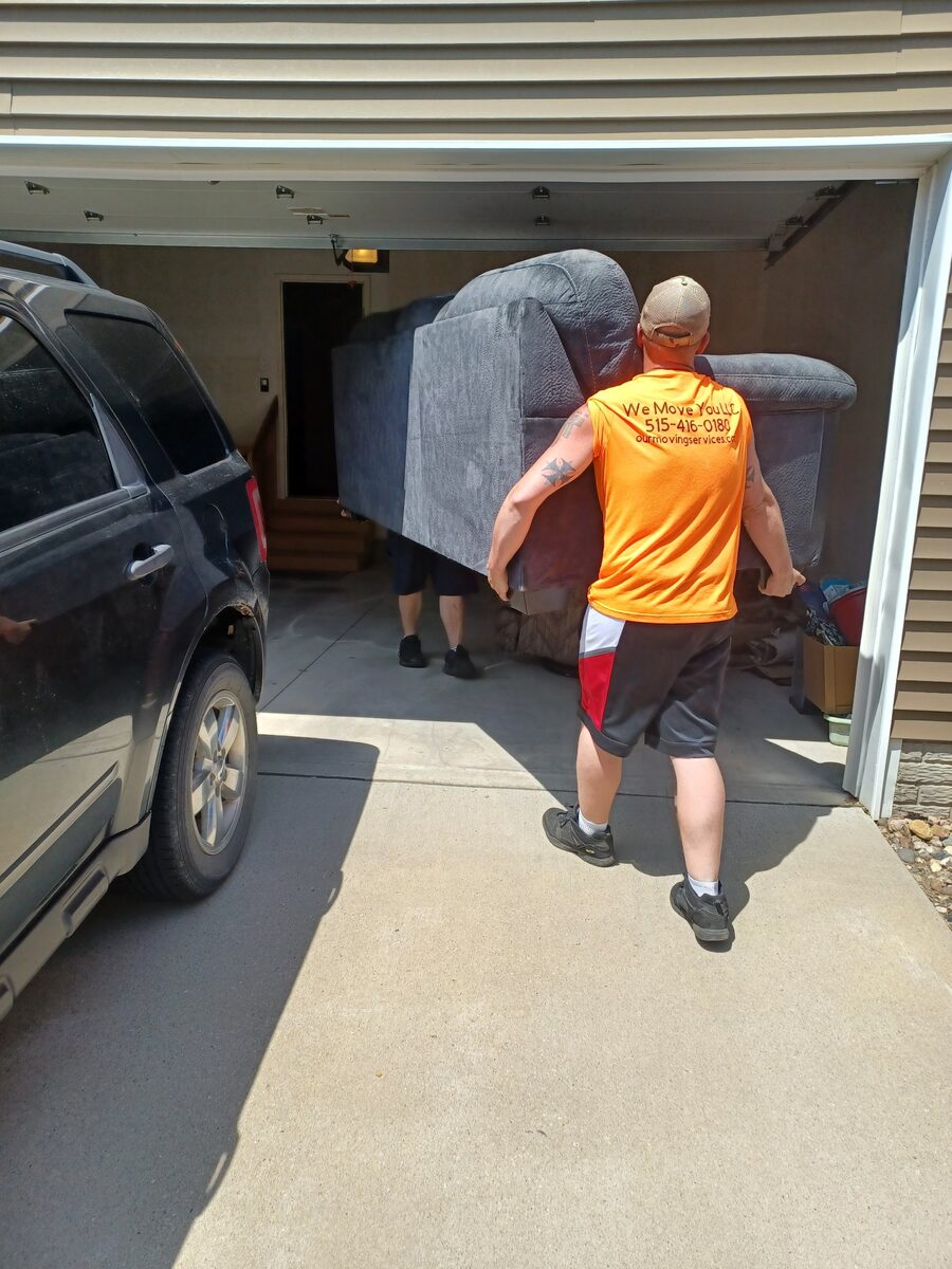We Move You crew moving a large sofa from a garage